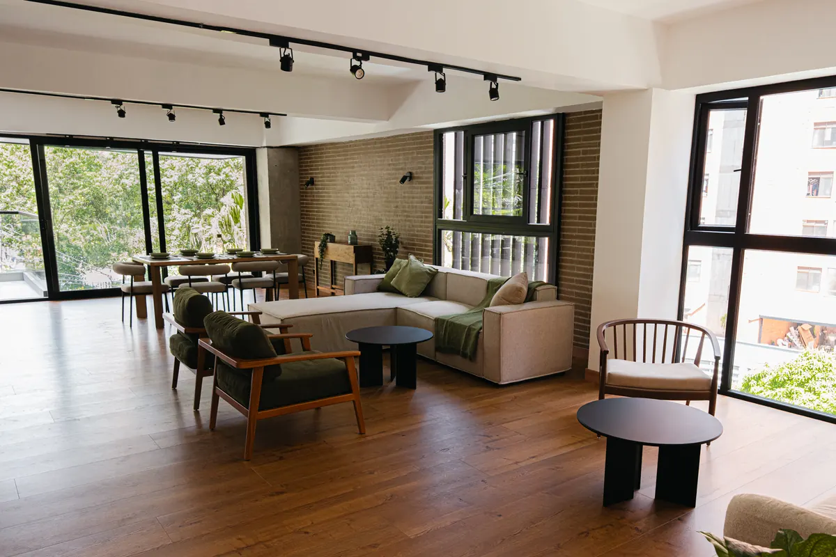 Sala y comedor del apartamento de 150 m² con ventanales al parque